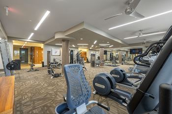 a gym with cardio machines and weights at the enclave at woodbridge apartments